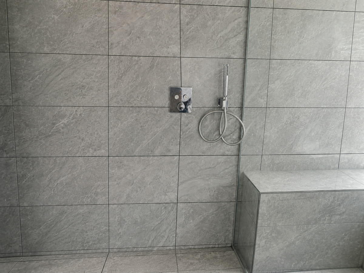 Shower enclosure finished in large-format tiles
