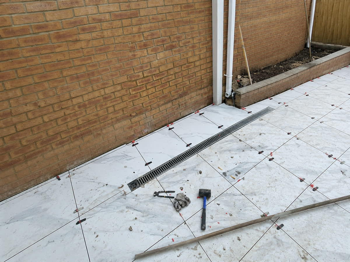 Marble patio slabs being laid in a rear garden